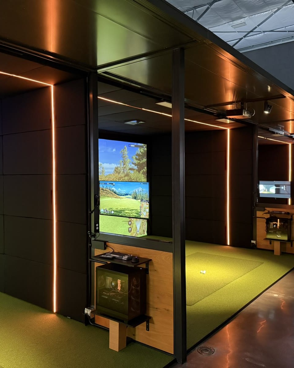 Rapid Bay interior — black magnetic panels with copper LED accents, mounted monitor and a simulator PC in its cabinet